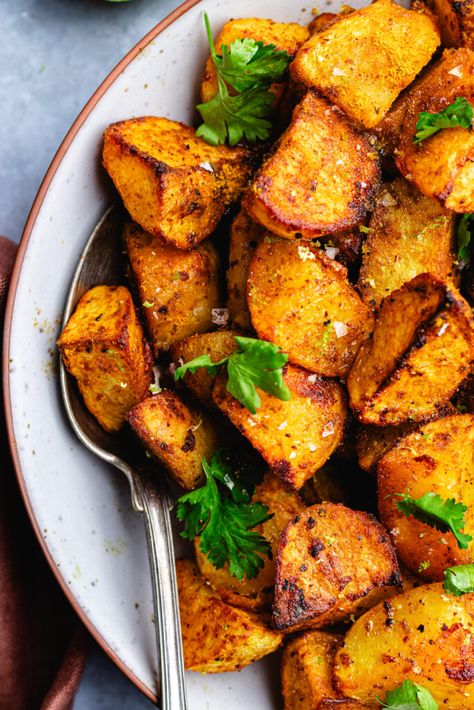 Curry roasted potatoes in a serving bowl topped with cilantro. Lamb Recipes Indian, Curry Potatoes, Indian Potato Recipes, Potatoes In Oven, Greek Potatoes, Indian Chicken Recipes, Potato Curry, Roast Potatoes, Curry Dishes