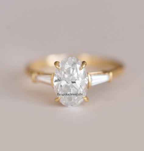 🐕 Big deals! 1.80 TCW Colorless Oval Cut Moissanite Wedding Ring in 18KT Yellow Gold | Three Stone Engagement Ring | Side Stones Baguette Cut Ring only at $125.0 Hurry. #WeddingRing #BaguetteRing #EngagementRing #YellowGoldRing #MoissaniteRing #ProposeRing #3StoneRing #OvalMoissaniteRing #GiftForHer #PlatinumRing Oval Diamond With Baguette Side Stones, Oval Engagement Ring With Side Baguettes, Oval Engagement Ring With Tapered Baguettes, Oval And Baguette Engagement Ring, Oval With Tapered Baguettes, Oval With Baguettes Ring, Oval Engagement Ring With Baguettes, Oval Cut Diamond Rings, Paper Rings