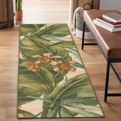 This flatweave indoor/outdoor area rug features a floral pattern, bringing a coastal feel to your living room or patio. It's power-loomed from polypropylene, and it features a large-scale image of green tropical leaves against a cream-colored background. With a 0.12" low pile height, this rug is great for softening your floors, while staying easy to vacuum. Best of all, this rug is stain-resistant, so it's ready to handle regular use. We recommend pairing it with a rug pad to keep it in place un Tropical Outdoor Rugs, Scale Image, Colour Spectrum, Safari Design, Rug Cream, Coloured Background, Sophisticated Decor, Green Banana, Banana Leaves