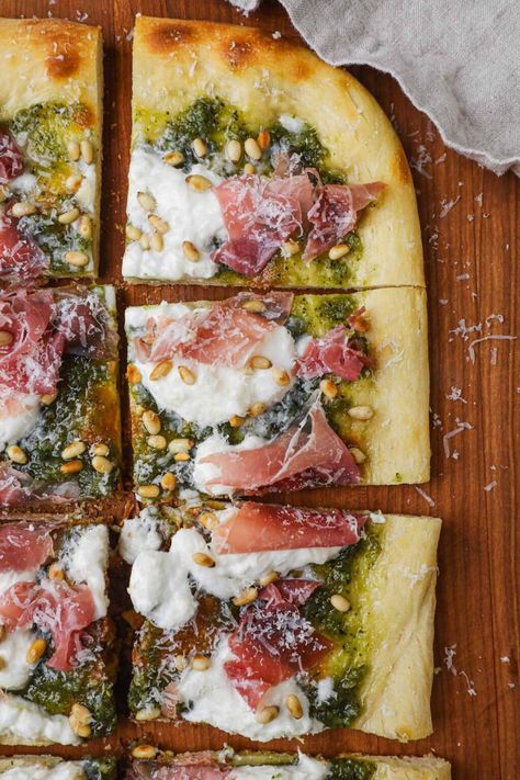 Pesto, Burrata, and Prosciutto Pizza is a gourmet treat that's ready in under 30 minutes. It features golden crust topped with vibrant basil pesto, creamy burrata, prosciutto, toasted pine nuts, and a sprinkle of grated parmigiano-reggiano. Each bite will leave you craving more! Burrata Meals, Vegan Prosciutto, Burrata Recipes, Pizza Burrata, Pesto Burrata, Unique Pizza Recipes, Burrata Pizza, Burrata Recipe, Pizza Gourmet