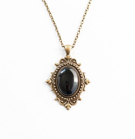 This Victorian inspired necklace is made from antique bronze chain and a black onyx cabochon housed in an ornate filigree setting. -the chain is 18 inches long -the pendant is approximately 2 inches long and 1.5 inch wide including the setting -lobster claw closure SHIPPING: Default shipping is by regular mail, which does not have tracking, shipping times are as follows: US: 1-3 weeks Canada: 1-2 weeks Europe: 2-4 weeks If you would like to add tracking for your parcel, please upgrade to Expedit Old Pendant Necklace, Vintage Necklace Antiques, Necklace Blue Stone, Black Gold Necklace, Jewelry Piercing, Victorian Necklace, Vintage Pendant Necklace, Raw Crystal Necklace, Filigree Jewelry