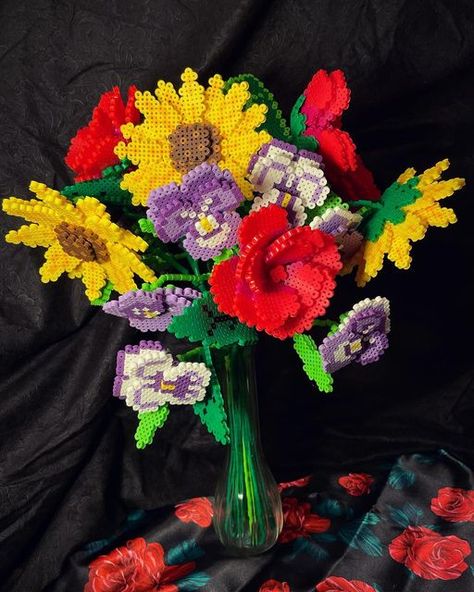 Amy Byte on Instagram: "Not your ordinary bouquet, these flowers are all made from perler beads! This took 3 days to make and probably around 30 hours. 4 stems of sunflowers, 5 stems of roses, and 3 stems of pansies. I’ll be posting a YouTube tutorial of the process soon so stay tuned! #perlerbeads #pixelart @perlerbrand" Perler Bead Bouquet, Perler Bead Flower Bouquet, Sunflower Perler Bead Patterns, Perler Bead Flowers, Perler Bead Flower, Mini Hama Beads, Hama Beads 3d, Beaded Bouquet, Seed Bead Projects