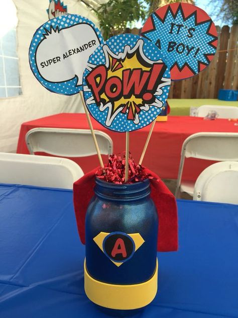 a super hero themed centerpiece with comics details Superman Baby Shower, Marvel Baby Shower, Superhero Centerpiece, Baby Dinosaur Party, Batman Baby Shower, Festa Power Rangers, Dinosaur Baby Shower Theme, Batman Baby, Superhero Baby Shower