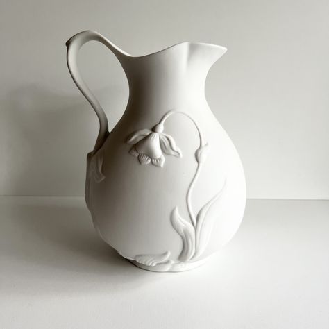 "This pitcher, jug or vase is stunning!  The 3D jonquil and leaf design on this bisque porcelain known as parian porcelain would be a lovely edition to almost any décor.  It is simple yet makes a statement.  So lovely as part of a white on white décor theme.  DIMENSIONS: 7\" wide x 9\"  tall   CONDITION: Excellent, no chips or cracks For more vases click here: https://etsy.me/3xPHpNm Return to the Vintagerous glass home page here: http://www.etsy.com/shop/Vintagerous ID#: 24-4-680-24-404-A-22" Large Wheel Thrown Pottery, Ceramic Vase Texture, Pottery Vase Ideas, Minimal Pottery, Textured Ceramics, Floral Ceramics, Jug Design, Carving Clay, Slab Vase