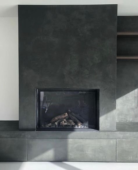 Gray Cement Fireplace, Dark Concrete Fireplace, Dark Plaster Fireplace, Stucco Fireplace Indoor, Black Limewash Fireplace, Concrete Fireplace With Wood Mantle, Black Concrete Fireplace, Black Plaster Fireplace, Concrete Look Fireplace