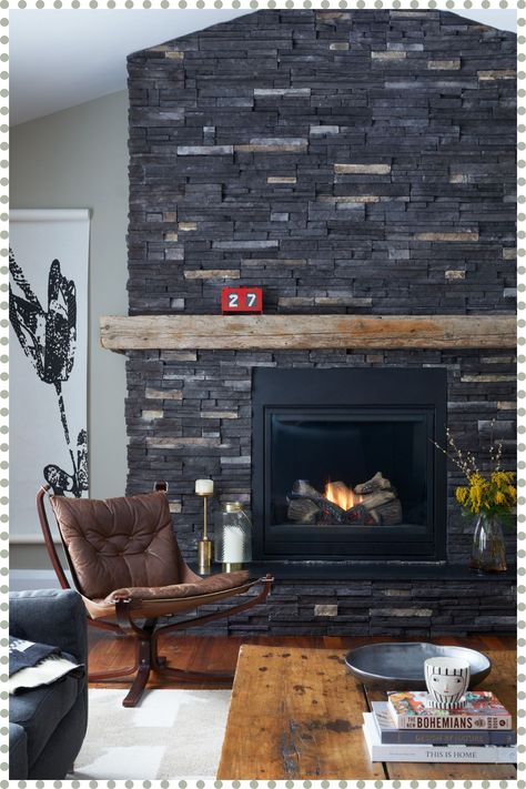 [PaidAd] Black Rundle Stone And Reclaimed Wood Create The Perfect Rustic Fireplace And Bring Ambience To This Family Room. Decorative Artifacts, Antique Furniture And Handmade Artwork Create An Environment That Is Layered And Interesting While Telling The Story Of The People Who Live There. #rusticfireplacesurround Black Rustic Fireplace, Black Stone Fireplace Wall, Slate Stone Fireplace, Dark Stone Fireplace Ideas, Dark Grey Stone Fireplace, Black Fireplace Stone, Black Painted Stone Fireplace, Black Stone Fireplace Ideas, Black Rock Fireplace