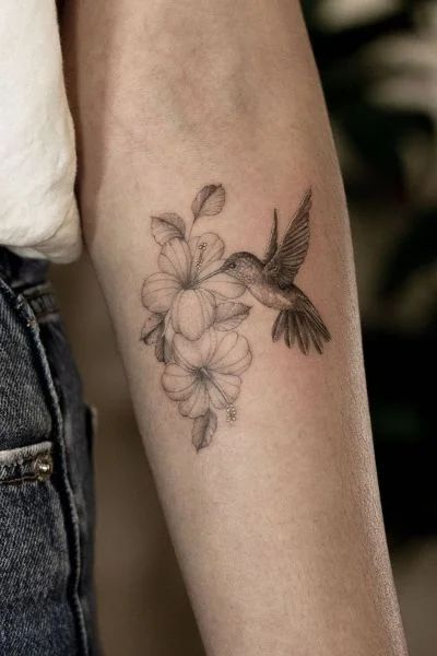 30+ Hummingbird Tattoo Designs for Graceful Ink - Tweakbee Hummingbird Tattoo With Sunflowers, Hummingbird Tattoo With Flowers Color, Hummingbird Cactus Tattoo, Hibiscus Hummingbird Tattoo, Cardinal And Hummingbird Tattoo, Hummingbird Tattoo Forearm, Hummingbird Tattoo Fine Line, Realistic Hummingbird Tattoo, Hummingbird And Flower Tattoo