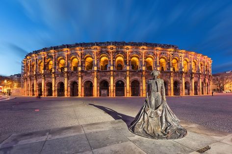 Nimes, France. Roman amphitheater (Arena of Nimes) at dusk and monument to bullfighter Nimes France, Pont Du Gard, Invisible Cities, History Project, Classical Antiquity, History Projects, Classical Architecture, Summer 24, Places Ive Been