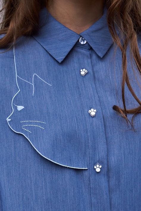 Introducing a new member of the Miss Patina cat-inspired design family. Simple yet sleek shape with a loose fit cut. This dress is elevated by our signature cat silhouette embroidery on the front right. With adorable paw-shaped buttons and blue and white buttons down the front with concealed pockets on both sides. Effortlessly style as a dress or layer as an overshirt. Crafted from a midweight rayon mix with a denim fabric giving you a more lightweight feel overall. Pair with brown ankle boots a Silhouette Embroidery, Miss Patina, Cable Knit Dress, Western Tops, Fashion Vocabulary, Trendy Fashion Tops, Embroidery On Clothes, Mode Casual, Cat Silhouette