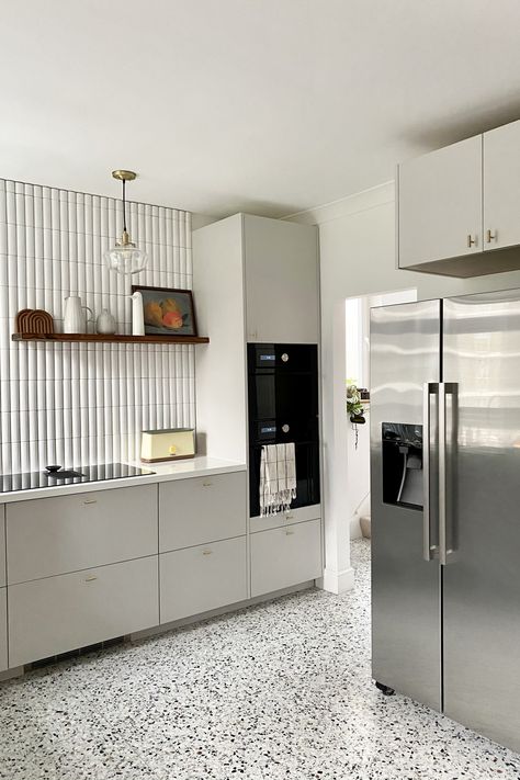 The new brown-and-black-speckled terrazzo floor from Diespeker & Co. replaced the existing mock wood vinyl. The brass cabinet pulls are Watt T-Bar Handles from Plank Hardware. “I thought VERY HARD about how to keep existing elements,” Ferren Gipson tells us. “I considered preserving the base cabinets and replacing the appliances and doors, but the cabinets that were there just didn’t make the most of the space and wouldn’t have allowed us to fit as much in.” Terrazzo Kitchen Floors, Terrazzo Kitchen Flooring, Terrazzo Floors Kitchen, Terazzo Kitchen Wall, Kitchen With Terrazzo Floors, Kitchen Terrazzo Floor, Terrazzo Floor Kitchen, Terrazzo Kitchen Floor, Terrazzo Flooring Kitchen