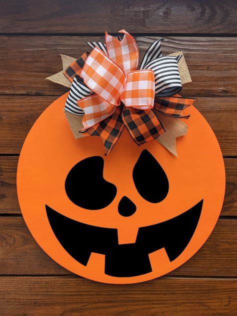 Halloween Door hanger YOU HAVE TO CHOOSE WHICH FACE YOU WANT ON DOOR HANGER, IF NONE IS CHOOSEN THEN FACE 5WILL BE USED!! MAKE SURE PICK WHAT YOU WANT  What a great way to add some fun to your front door. Lovely colors with bow. This piece comes ready to hang , can also be used indoors. A great piece for any time. These signs make a great statement to any home decor. They are made of 12 OR 18 inch round. Comes with felt on back so it doesn't hurt the doors. they are are not heavy and look great October Door Hanger, Door Hanger Halloween, Halloween Decor Front Door, Diy Halloween Door Hanger, Pumpkin Door Hanger Wooden, Halloween Door Signs, Wooden Halloween Signs, Pumpkin Halloween Decor, Door Hanger Bow