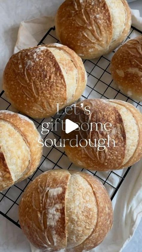 Emily, a passionate sourdough enthusiast, shares her delightful idea of gifting sourdough for the holidays. She crafted a batch of mini sourdough loaves, each weighing 70 grams, after a 15-hour cold ferment. These loaves were baked for 25 minutes, and for a special touch, wrapped in parchment paper and tied with twine. Perfect for sharing, these loaves are a testament to the joy of homemade baking. Follow her for more insights and homemade recipes. Mini Sourdough Loaves Christmas, Mini Artisan Bread Loaves, How To Gift Homemade Bread, Gifting Bread For Christmas, Sourdough Bread Christmas Gift, Sourdough Gift Basket Ideas, Gifting Homemade Bread, Homemade Bread Gifts For Christmas, Mini Sourdough Loaves For Gifts