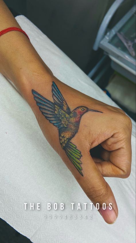 Hummingbird Tattoo On Hand, Green Hummingbird Tattoo, Unique Hummingbird Tattoo, Hummingbird Hand Tattoo, Hummingbird Tattoo For Men, Bird Tattoo On Hand, Hummingbird Tattoo Color, Hummingbird Memorial Tattoo, Traditional Hummingbird Tattoo