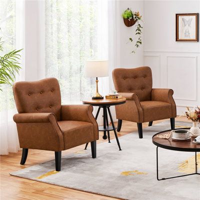 This accent chair combines mid-century modern design with traditional elegance. Its frame is made from solid and engineered wood, and it's wrapped in padded faux leather with a weathered brown hue for a textured and supported feel while you sit. The dramatic winged back rolled armrests, and black-finish tapered legs create a dignified look for your seating area. We love how the button-tufted accents on the backrest add a touch of refinement. Plus, the front legs feature adjustable feet that adap Single Apartment, Leather Wingback Chair, Leather Wingback, Accent Chairs & Armchairs, Leather Accent Chair, Upholstered Armchair, Mid Century Armchair, Leather Couch, Accent Arm Chairs