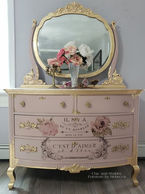 Finished! This vintage dresser makeover was done in Dixie Belle Tea Rose, re•design with prima transfers, gold leaf and added the transfers to the drawers. Most of the knobs were missing. So I purchased these vintage french knobs.   #chicandshabbyfurniturebyrebecca#rusticelegance #cottagedecor #homedesign#farmhouse #fixerupper #vintagestyle#hgtv#handpaintedfurniture#Goldleaf#bestpaintonplanetearth#chalkmineralpaint #pink #easypeasypaint#dixiebellepaint #gold #vanity #redesignwithprima #transfer Black Dresser Decoupage, Pink And Gold Painted Furniture, Painted Antique Vanity Ideas, Vintage Dresser Makeover, Muebles Shabby Chic, Shabby Furniture, Gold Dresser, Pink Furniture, Decoupage Furniture