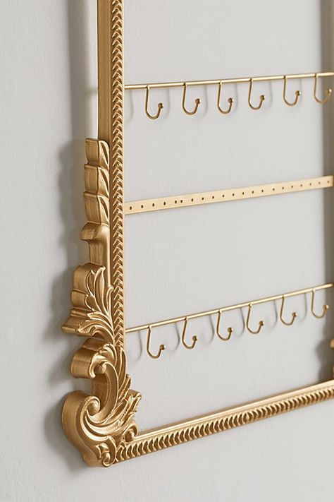 Turn your jewelry collection into a statement centerpiece with this jewelry organizer featuring four tiers made up of a mix of hooks for your necklaces and perforations for your earrings. Finished with intricate detailing around the frame. Features Statement jewelry holder Ornate sculpted frame crafted from wood Gold finishes for an antique feel 4 Tiers - hooks for necklaces & perforations for earrings! Content + Care Wood, iron Spot clean Imported Size Dimensions: 16" l x 0.7" w x 20" h Weight: Aesthetic Jewelry Organizer, Urban Outfitters Jewelry Holder, Aesthetic Jewelry Holder, Jewelry Organizer Aesthetic, Cool Decorations, Jewelry Storage Ideas, Jewelry Wall Display, Ornate Jewelry, Mirror Jewelry Storage