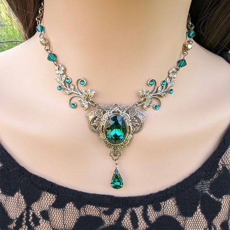 This vintage medieval styled crystal necklace features lush Emerald Swarovski crystals with nice crisp facets and brass/sterling silver embellishments. The detailed flower stampings have been in production since the 1940's and give the necklace a beautiful elven-like quality. Both elegant and stylish, this piece would be perfect for weddings, proms and other formal occasions.   Swarovski Crystals are made in Austria and are the highest quality lead free glass-cut crystals on the market, with ext Antique Emerald Necklace, Emerald And Gold Necklace, Fantasy Necklace Art, Fantasy Jewelry Necklace, Emerald Jewelry Necklace, Victorian Jewelry Necklace, Medieval Necklace, Fantasy Necklace, Elven Jewelry