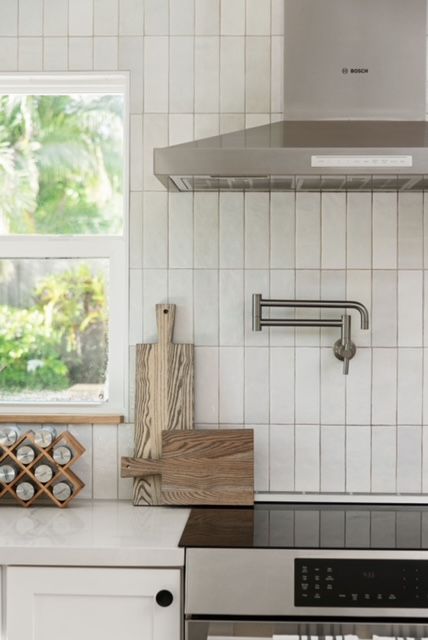 Step into the dreamiest of modern coastal kitchens at Lindross Remodeling! 💖🌊✨ With our elegant dimensional vertical stacked subway tiles and white cabinets you won't want to leave. Pin this kitchen for later and start planning your own coastal haven! 🏡✨📍 Pin for later!📌 #lindrossremodeling #lindrosshome #subwaytile #whitesubwaytile #moderncoastal #californiacoastal #tampadesign #tampadesignbuild #tamparemodel #potfiller #cuttingboard #woodaccents White Subway Tiles Kitchen Backsplash, Seaside Kitchen, Modern Coastal Kitchen, White Subway Tile Kitchen, White Tile Kitchen Backsplash, Custom Kitchen Remodel, Beach Style Kitchen, Modern Kitchen Backsplash, Subway Backsplash