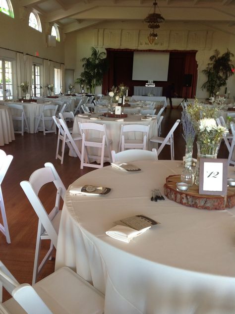 Reception Room at The Thursday Club. White Resin Chairs, Ivory Linens, and Ivory Napkins. Catering by Jaramillo Catering. #SanDiegoWeddings #PattysLinenRentals #JaramilloCatering #ThursdayClub #Ivory #Simple #Earth #Wood #TreeTrunks White Vs Ivory Table Linens Wedding, Ivory Vs White Table Linens, White Chairs Wedding, Napkins Wedding Table, Antique Style Wedding, Wedding Guest Table, White Chairs, Wedding Table Linens, Napkins Wedding