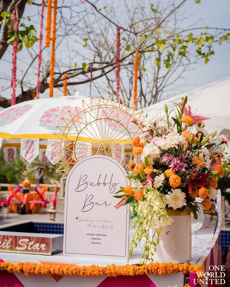 Bringing alive a festive reverence with shades of tangerine and fuschia fused together on a sunny afternoon. 📞 097995 35809 📩 oneworldunitedoffice@gmail.com #wedding #weddingdecor #eventmanagement #decor #indianweddings #florals #eventdecor #weddingday #mehndifunction #mehendiceremony #mehendidecor #vibrantmehendidecor #floralarrangement #floaldecor #mehendievent #eventplanner #mehendisetup Pink And Yellow Haldi Decor, Vibrant Haldi Decor, Mehndi Function, Bubbly Bar, Sunny Afternoon, Event Management, Event Decor, Indian Wedding, Real Weddings