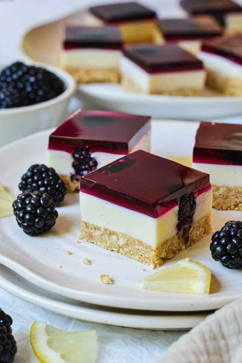 This easy jelly slice recipe is the perfect no-bake treat. A twist on classic jelly slice, it contains a buttery biscuit base and a creamy lemon and condensed milk filling; dotted with bursts of fresh blackberries and topped with luscious blackberry jelly. With just 7 ingredients and only 10 minutes of prep time, this bright, colourful and nostalgic dessert is a must-try! Australian Desserts, Jelly Slice, Milk Jelly, Spring Recipes Dessert, Sugar Replacement, Jelly Desserts, Slice Recipe, Colorful Desserts, Custard Cake