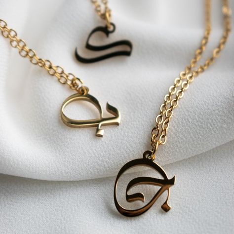 Beautiful, unique design, Arabic Islamic Calligraphy-Style Letters necklace pendant. Only a selection of initials are available at the moment! Listed below: Alif (ا), Baa (ب), Jeem (ج) , 'Ain (ع), Kaaf (ك) , Meem (م), Haa (ه) #arabic #pendant #letters #necklace #jewellery #goldplated18k #elhadiuk Necklace Name Design, Letters Necklace, Diy Leather Bracelet, Islamic Jewelry, Engagement Rings Couple, Letter Jewelry, Fancy Jewellery Designs, Jewelry Photoshoot, Metal Clay Jewelry