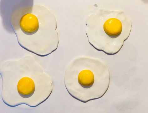 New to my shop (and the first pieces I've ever sold!) are these sunny-side-up fried egg sculptures. Each one is sculpted by hand with polymer clay, baked, hand painted, and finished with a glossy varnish. Each egg is a one of a kind, signed and numbered piece. Order today and support a creator's love of creating :) Egg Clay Art, Ceramic Food Sculpture, Polymer Clay Egg, Egg Sculpture, Africa Craft, Ceramic Egg, Food Sculpture, Clay Magnets, Clay Diy Projects