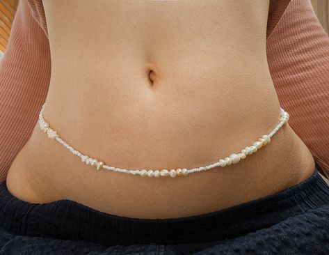 Celebrate self-love and embrace your body with these handmade waist beads, featuring a beautiful blend of beautiful high quality freshwater pearls and white seed beads. Each strand is crafted with care, offering a timeless and elegant accessory that enhances your natural beauty and inspires confidence. Materials: Freshwater pearls in varying sizes and natural shades High-quality white seed beads Strong wire threading for long-lasting wear Features: Customizable to your size Lightweight and easy Body Jewelry Diy, Jeans Chain, Crochet Christmas Ornaments Free, Waist Jewelry, Crystal Bead Jewelry, Waist Beads, Beads Bracelet Design, Thread Jewellery, Belly Chain