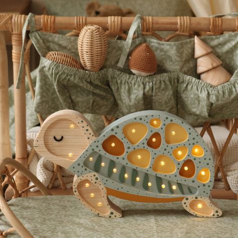 Introducing our serene Turtle Lamp, the perfect coastal companion for your little one's bedroom! Handcrafted from 100% natural pinewood, this adorable turtle embodies both durability and charm, effortlessly complementing any seaside-inspired decor. With its adjustable brightness and convenient timer, your little explorer can slowly drift off to sleep, guided by the tranquil glow of their very own seaside friend. Every Little Lights lamp is hand made, hand painted, and built from natural pine wood – so they don’t just last through childhood, they last generations. Little Lights is a family owned and operated business, all of their unique, handmade products are individually and carefully manufactured at their workshop (and home) in Krakow, Poland. Product Details: Dimensions: 13" x 8" x 2" E Nursery Turtle Theme, Sea Turtle Nursery Theme, Nursery Lamp Ideas, Turtle Nursery Theme, Aquarium Nursery, Sea Turtle Nursery, Wall Led Lights, Turtle Lamp, Frog Nursery