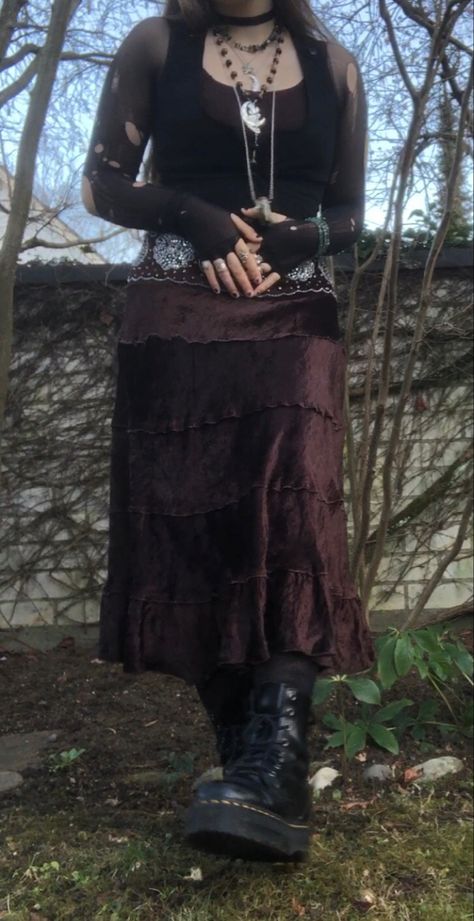 A mid-size person/girl wearing mate rose lipstik, a black tight waistcoat with a ripped stocking selfmade longsleeve and a thrifted dark brown maxi skirt, black dr. Martins and multiple crystal rings and bracelets. 	The person is also wearing multiple silver necklaces, one in form of a dragonfly and another in form of a moon, a green crystal bead necklace and a black lace choker. Dark Cottage Core Outfits, Fairy Goth Outfit, Fit Aesthetic Outfit, Goblin Forest, Grunge Fairycore Outfits, Dryad Costume, Ripped Stockings, Grunge Plus Size, Fem Style