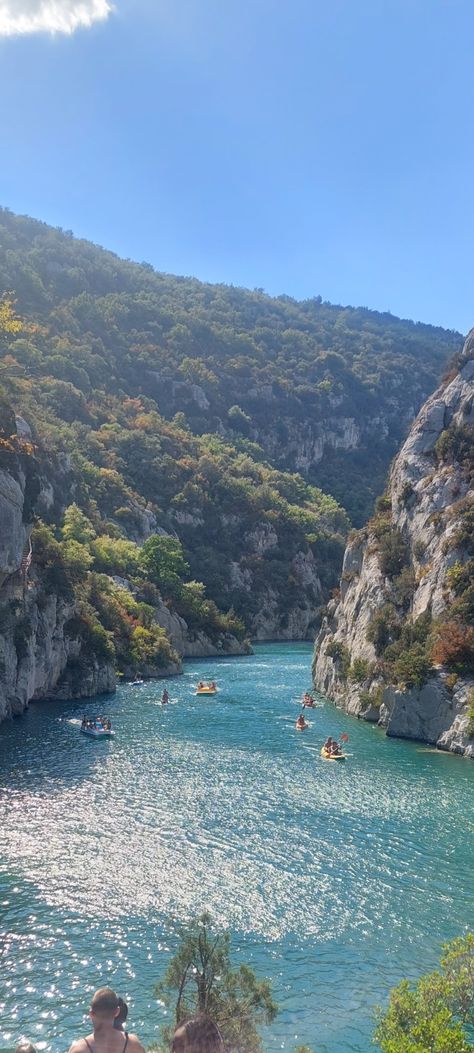 Blue river surrounded by grey mountains with boats Holidays Aesthetic, Travel In France, Moustiers Sainte Marie, Summer Mountains, Aesthetic Places, French Summer, France Aesthetic, Streets Of Paris, Places In Europe