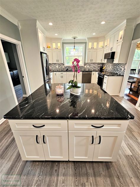 ⚫ ⚪ A bold black and white color scheme sets the tone for this contemporary #kitchendesign. Matte black hardware and a black granite countertop contrast the white cabinetry throughout the kitchen, including the large island. ✨Find your ideal kitchen style and let our team help you bring it to life! Black Granite Kitchen Island, Cambrian Black Granite, Farmhouse Kitchen Granite, White Kitchen Black Countertop, Black Countertops Kitchen Color Schemes, Granite Countertops Black, Black Countertops White Cabinets, Kitchens With Black Granite Countertops, Black Granite Countertops Kitchen