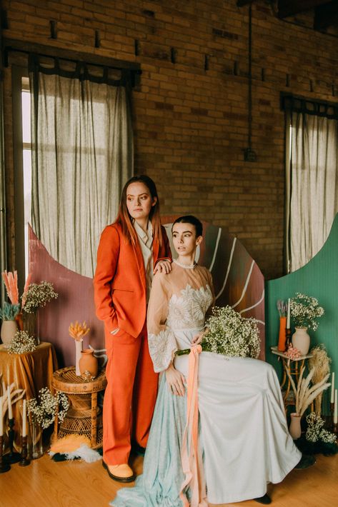 "My vision for the shoot was to pack it full of color, queerness, and tender moments for this sweet couple - and Lexi + Sarah certainly delivered." The post Colorful wedding inspiration with funky rainbow backdrop and bold orange suit appeared first on Equally Wed, modern LGBTQ+ weddings + LGBTQ-inclusive wedding pros. Lgbtq Wedding Photos, Queer Wedding Suit, Queer Wedding Photos, Colorful Wedding Suit, Queer Wedding Ideas, Alternative Wedding Outfit, Masculine Wedding, Punk Wedding, Lgbtq Weddings