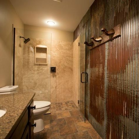 Totally rustic and rugged, this is definitely a bathroom fit for a man. From organically rusted steel walls and pounded steel mirror frame, to the faux weathered vanity and complementing light fixture, all in style and are perfect details on the earth toned tile on floor and natural stone shower wall panels. So much personality, you will forget this is an average size bathroom! Metal Shower Walls Corrugated Tin, Tin Bathroom Ideas, Corrugated Metal Bathroom, Tin Shower Walls, Metal Shower Walls, Tin Shower, Tin Bathroom, Metal Bathroom Walls, Rugged Man