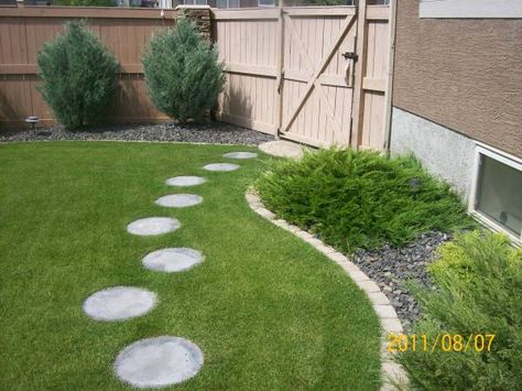 These round stepping stones lead to the back patio area. Placing them with the right spacing and offsetting them, is the key achieving the right look even with a manufactured product. Round Pavers, Round Stepping Stones, Stone Backyard, Stepping Stone Pathway, Stepping Stone Walkways, Stepping Stone Paths, Walkway Landscaping, Outdoor Walkway, Walkway Ideas