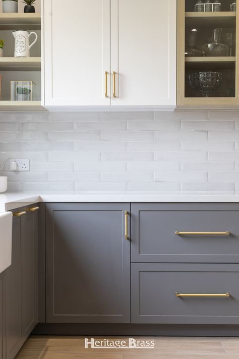 In this kitchen renovation Satin Brass Bauhaus cabinet handles have been beautifully paired with white and grey kitchen cabinets. The golden tones of the hardware are luxurious and eye-catching, adding warmth to the kitchen.   Photography @claudiestrydom Satin Brass Kitchen Hardware, White And Grey Kitchen Cabinets, White And Grey Kitchen, Modern Shaker Kitchen, Shaker Kitchen Design, Brass Kitchen Hardware, Brass Cabinet Pull, Kitchen Photography, Shaker Kitchen Cabinets