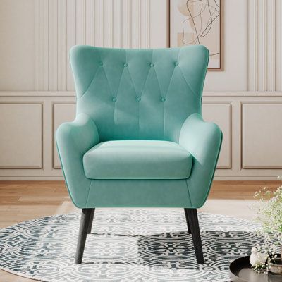 This armchair features a classic wingback silhouette and plenty of padding for your living room or a small reading nook anywhere. It has an engineered wood frame that rests on tapered, angled dowel legs in a black tone. Wrapped in velvet, this accent chair comes in a solid hue and has a foam-filled seat for just the right amount of support. Flared arms and a tufted back complete this modern twist on a traditional design. Plus, it has a weight capacity of 300 lbs. To care for this chair, simply s Velvet Wingback Chair, Blue And White Living Room, Wingback Armchair, Elegant Dining Room, White Living Room, Cushion Seat, Modern Armchair, Green Chair, Colour Light