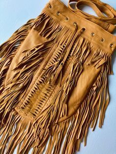 Exterior Women's Western Crossbody Purse With Fringe Vegan Designs | Trend In 2023 | Hand Bags Ideas The exterior of a women's western fringed crossbody bag, often made from vegan materials, features a distinctive and elegant design that combines elements of western and bohemian fashion. Fringe is a defining feature of Western and Bohemian styles. These bags often have fringe details hanging from the sides or bottom of the bag, giving them a fun, free-spirited feel. The crossbody design offers Western Crossbody Purse, Hand Bags Ideas, Purse With Fringe, Vegan Design, Leather Fringe Bag, Native American Flute, Bags Ideas, Fringe Crossbody Bag, Cowgirl Chic