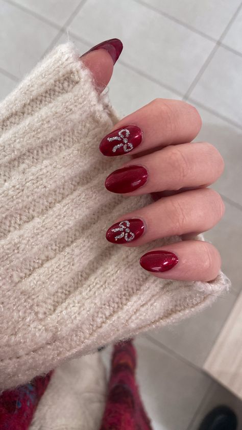 a picture of my hand, i did my nails in an almond shape with shiny red polish, on my index and ring finger i painted sparkly little bows Biab Nails Christmas, Christmas Bauble Nails, Christmas Nails Biab, Christmas Gel Nails Short, Christmas Bow Nails, Bow Nails, Nail Goals, 2023 Nails, Gel Extensions