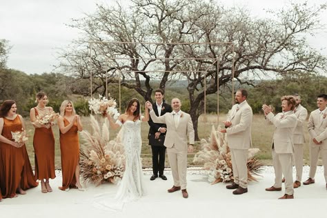 Shelby + Kyle's terracotta and rust modern boho wedding at Mae's Ridge in Texas Hill Country featured pampas grass wedding decor, dried florals, rust ceremony and reception details, and lots of boho vibes! Bride wearing sleeveless boho lace wedding dress, groom wearing tan suit, bridesmaids wearing rust long dresses. Pampas grass ceremony decor Florals \\ Good Seed Floral Photo \\ Brooke Taelor Photo Venue \\ Mae's Ridge Gown \\ Lover’s Society Tan And Rust Groomsmen, Terracotta And Pampas Grass Wedding, Terracotta And Khaki Wedding, Tan Suit Fall Wedding, July Boho Wedding, Tan Groomsmen Suits With Terracotta, Boho Wedding Bride And Groom, Rust And Tan Wedding Decor, Boho Terracotta Wedding Groomsmen