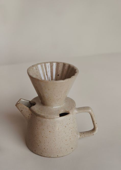 Brighten up your mornings with the Ratih Pour Over. Handmade in smooth ceramic in a V-shaped cone design with ribbed inner design to lengthen the extraction process for a greater brew. Pairs perfectly with Ageng Tea Pot / Speckled Cream. This pour over is part of the Kayu Studio ‘Tanah Liat’ Collection — which directly translates into Clay Collection in Javanese. This handmade collection is made by our skilled partners in Java, Indonesia. Dedicated to ethical practices, this little ceramics stud Ceramic Drip Coffee, Pour Over Ceramic, Pottery Creative Ideas, Ceramic Coffee Pour Over, Ceramic Pour Over, Tea Pot Pottery, Pitcher Design, Pottery Kitchenware, Tea Pot Ceramic