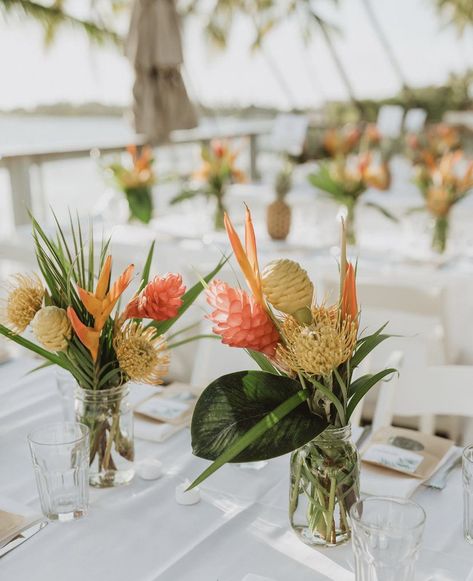 Mason Jar Tropical Centerpieces, Tiki Wedding Centerpieces, Tropical Floral Arrangements Simple, Tropical Floral Table Arrangements, Tropical Flower Table Arrangements, Waimea Falls Wedding, Hanging Flower Lights, Hawaii Table Decorations, Railing Decorations Party