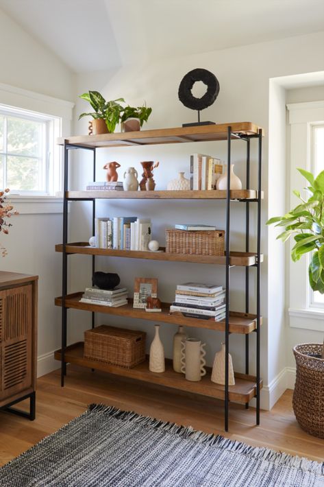 Crafted of wood with a warm vintage-acorn finish, the Kaili Bookshelf features rectangular open shelves in a sleek matte-black metal frame. Designed for versatile uses, this bookshelf is perfect for arranging with decor or plants in the living room, using as open storage in the bedroom or office and organizing serveware in the dining room or kitchen. #WorldMarket #AntonOfficeCollection #HomeOffice #HomeDecor Black Metal Bookshelf, Market Shelf, Office Furniture Decor, Unique Living Room Furniture, Wardrobe Laminate Design, Black Metal Shelf, Dining Room Shelves, Small Apartment Bedrooms, Shelf Decor Living Room