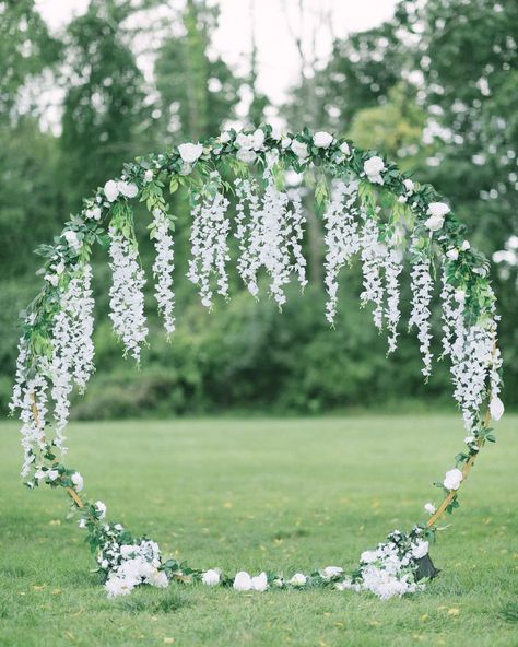 How gorgeous is this stunning circular arbor! Its unique design created a breathtaking focal point for the ceremony, beautifully adorned with white florals and greenery. The combination of blooms and foliage added a touch of romance and elegance, making it the perfect backdrop for the couple's vows. Round Arch For Wedding Ceremony, Wisteria Circle Arch, Circle Arch With Flowers, Circular Arbor, Wedding Arch Circle, Ceremony Arch Flowers, Arbor Decor, Circle Arch, Round Arch