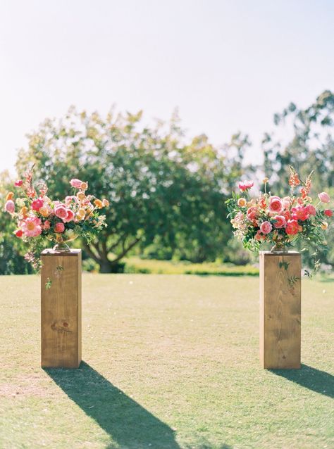 Ceremony vow area floral arrangements on wooden pedestals. Pink large arrangements with coral charm peonies, pink roses, and pink ranunculus, and greenery shot on film by Cavin Elizabeth Photography. Ceremony Backdrop Outdoor, Alter Flowers, Ceremony Arrangement, Wedding Alters, Spring Wedding Decorations, Aisle Flowers, Wedding Ceremony Arch, Wedding Altars, Wedding Ceremony Backdrop