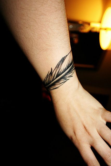 Nice idea for a feather tat to go around the wrist, not just behind! A Feather Tattoo, Feather Tat, Wrist Tattoos Girls, Wrist Bracelet Tattoo, Simple Wrist Tattoos, Universe Tattoo, Cool Wrist Tattoos, Armband Tattoos, Wrist Tattoos For Guys