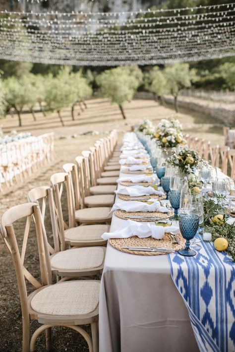 Simple natural blue and citrus yellow wedding table decor and string light set up for finca wedding reception dinner in Mallorca | photo @mariahibbsphotography Mediterran Dinner, Mallorca Wedding Table, Greece Table Decor, Mediterranean Table Setting Wedding, Blue And Yellow Wedding Table Decor, Wedding Decor Light Blue, Lemon Wedding Table Decor, Yellow And Blue Table Decor, Mediterranean Blue Wedding