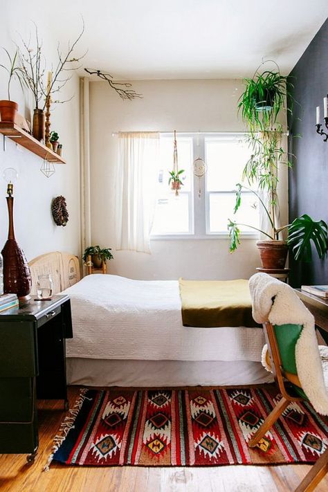 If it's small, bring the outside in. The abundance of greenery makes this tiny bedroom come to life. Oh, and that gorgeous Mexican rug definitely helps too. Bilik Kecil, Feng Shui Interior Design, Nyc Bedroom, Botanical Bedroom, Minimalist Dekor, Made Bed, Deco Boheme Chic, Small Apartment Bedrooms, Interior Boho