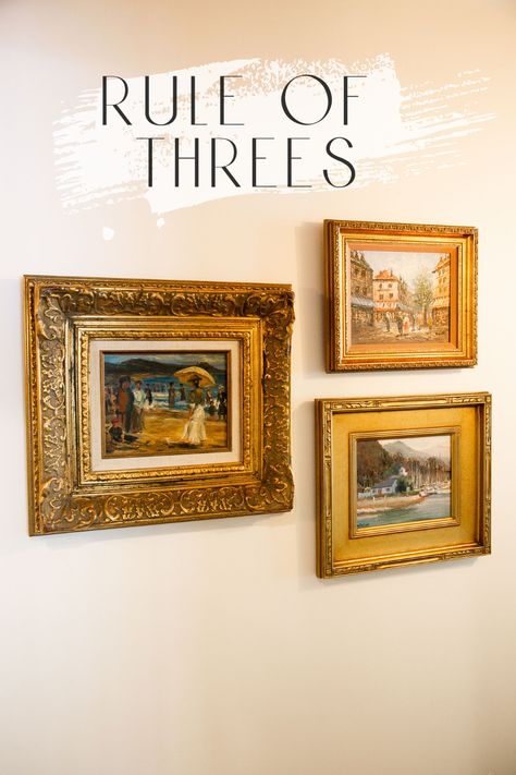 Three gold picture frames arranged on a cream colored wall. The rule of threes.simple design tip to make life easy and your home awesome! Arranging Wall Decor, Wall Gallery Layout Templates, Five Frame Gallery Wall, Ways To Hang 3 Pictures On A Wall, Arranging 3 Pictures On Wall, Paintings Arrangement On Wall, Small Gallery Wall 3 Frames, Arranging Art On The Wall, Grouping Art On Wall