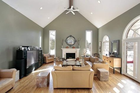 A simple formal living room with beige sofa set on top of the hardwood flooring. The fireplace looks perfect together with the white vaulted ceiling. Vaulted Ceiling Paint Ideas, Cathedral Ceiling Living Room, Vaulted Ceiling Ideas, Vaulted Ceiling Lighting, Vaulted Ceiling Living Room, Living Colors, Types Of Ceilings, Colored Ceiling, Living Room Ceiling